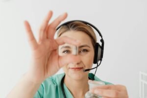 Female doctor in headset holding pill during online medical consultation, emphasizing telehealth.