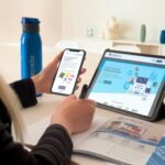 a woman sitting at a table using a tablet