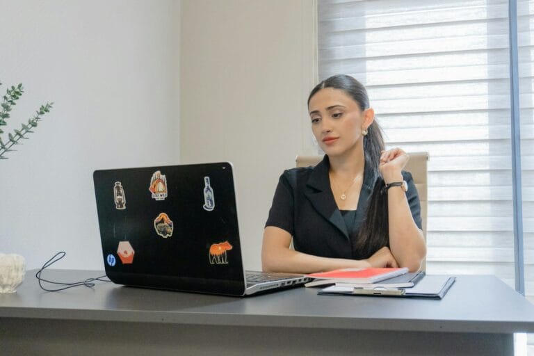Woman Working On A Laptop At A Desk.