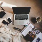 white ceramic mug near MacBook Pro