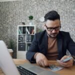 a man sitting at a table in front of a laptop